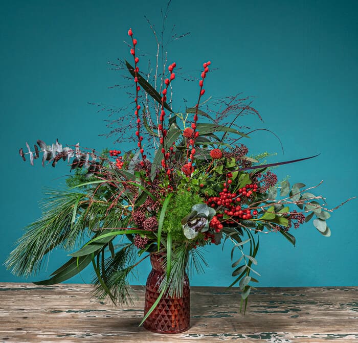 jarron navideño con flores y plantas